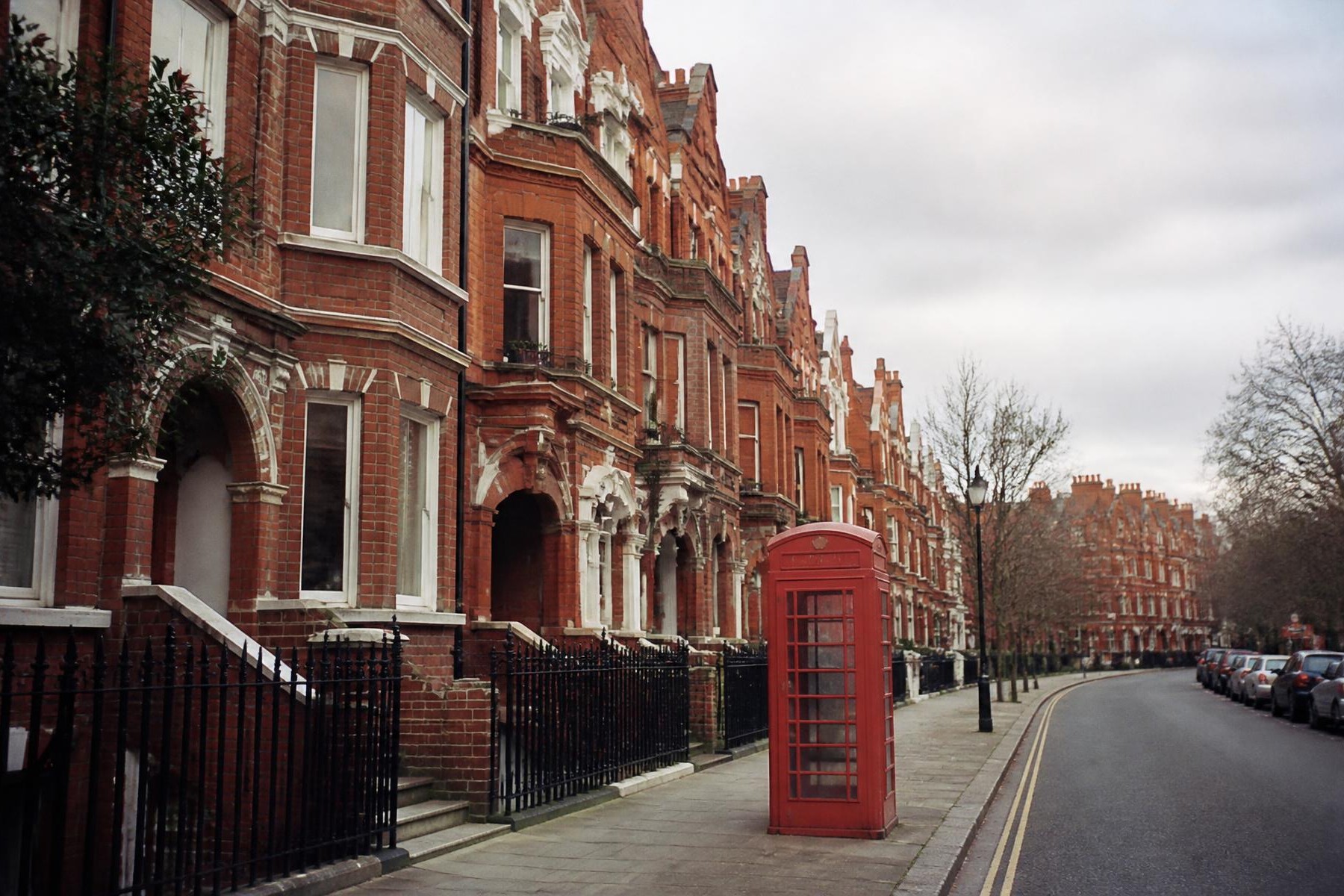 Fachadas de tijolo e cabine vermelha sob céu cinza em Londres, roteiro personalizado em Londres, Inglaterra